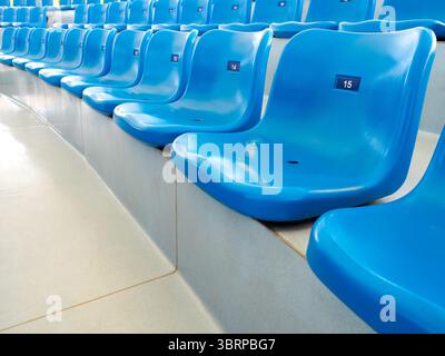 Empty blue plastic seats or stadium chairs with numbers in aquarium show or stadium. Rows of seats pattern, on the steps with nobody. Stock Photo