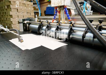 Precision glue applicator efficiently spreads adhesive on materials in a modern manufacturing facility Stock Photo