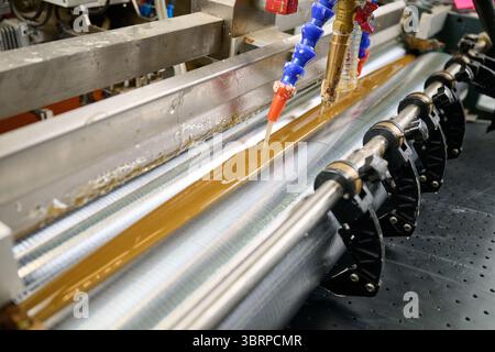 Efficient glue application in industrial machinery enhances precision in production processes Stock Photo