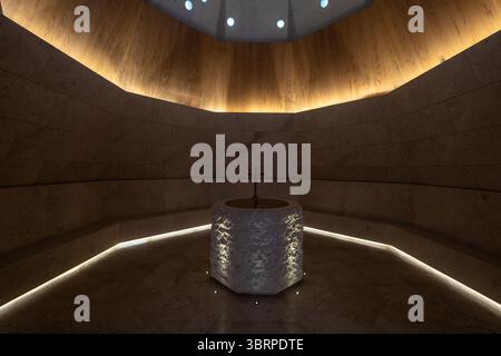 Contemporary Chapel with Octagonal Baptismal Font, dark and moody interior design background Stock Photo