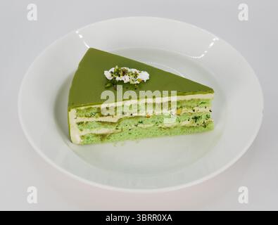 Viral Dubai Chocolate bar cake with pistachio cream and kunefe filling, Creamy Pistachio Cheesecake isolated on white, background Stock Photo