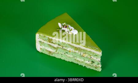 Pistachio Layer cake with whipped cream frosting and topped with fresh pistachio nuts isolated on background, Viral Dubai chocolate cake Stock Photo