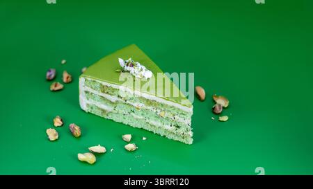 a slice of Pistachio cream cake isolated on background, Viral pistachio kunafa pastry cake, Pistachio cheesecake photography Stock Photo