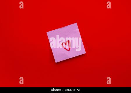 Hand drawn red heart on a post it sticky note on a deep red background Stock Photo