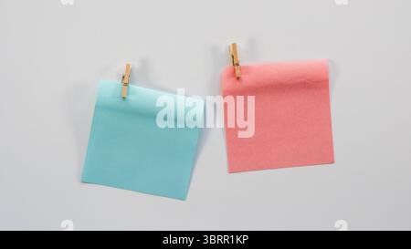 blue and pink sticky notes with wooden clips isolated on white background, boy OR girl gender reveal background, baby shower decor wallpaper Stock Photo