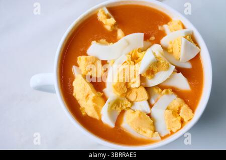 Close up of traditional spanish cold tomato soup, salmorejo, topped with chopped hard boiled eggs, offering a refreshing and flavorful culinary experi Stock Photo