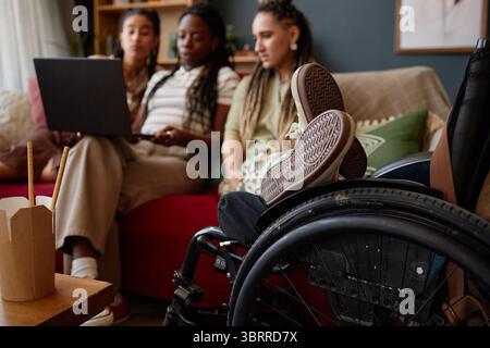 Diverse Young Adult Women Collaborating on Laptop with Disability Representation Stock Photo