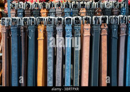 Leather belts in various colors displayed in a store. Stock Photo