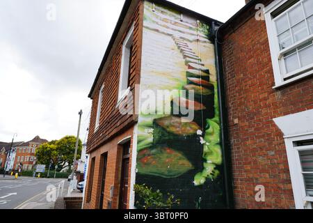 Street Corner Brick Building Featuring Artistic Mural of Stone Pathway Painting. Dorking, England Stock Photo