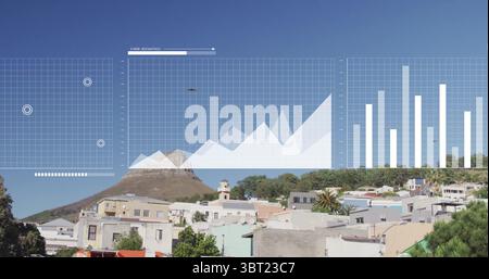 Displaying digital grid, area and bar charts hovering above hillside area, pastel houses, drone Stock Photo