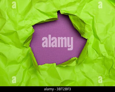 Lime Green Crumpled Paper Reveals Purple Background Stock Photo