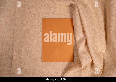 Minimal brown card on beige linen fabric aesthetic flat lay background with copy space Stock Photo