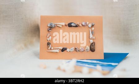 Beautiful Handmade Gift Card for Festive Use with Space for Copy Text, ocean beach inspired seashell frame Stock Photo