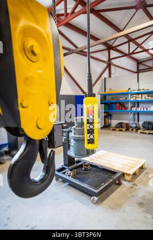 Close up of an overhead crane remote control hanging in a factory, ready to operate lifting machinery Stock Photo