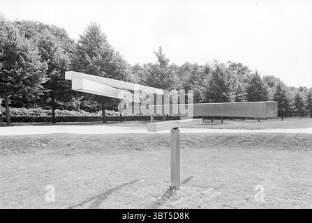 Exhibition Felison Exhibition IJmuiden The Netherlands, Whizgle News, Dutch Desk, The Netherlands, 1950 - 2000 on 15-07-1981. The image shows these topics. The scene showcases a minimalist outdoor sculpture composed of sleek, metallic elements. Three elongated bars, each reflecting light in different angles, are suspended in a seemingly weightless arrangement, creating a sense of dynamic movement. The bars are mounted on a simple pedestal, emphasizing their modernist design. Surrounding the sculpture is a well-maintained grassy area, lush and evenly trimmed, that contrasts with the sharp, indu Stock Photo