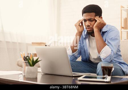 Concentrated black man analizing information on laptop Stock Photo