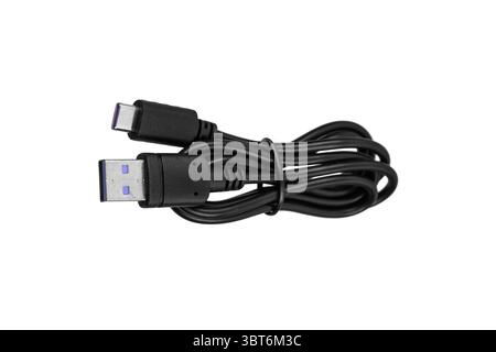 Black USB-A to USB-C charging cable coiled and ready for use. Stock Photo