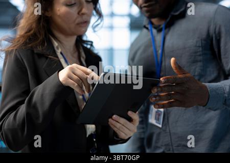 Data center software developers using laptop, conducting security audits, preventing errors. Close up of coworkers doing brainstorming, using device to review firewall rules, logging incident details Stock Photo
