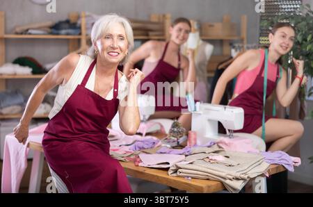 team of dressmakers doing a warm-up in the workshop Stock Photo