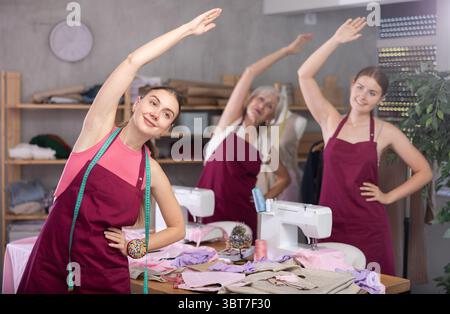 team of dressmakers doing a warm-up in the workshop Stock Photo