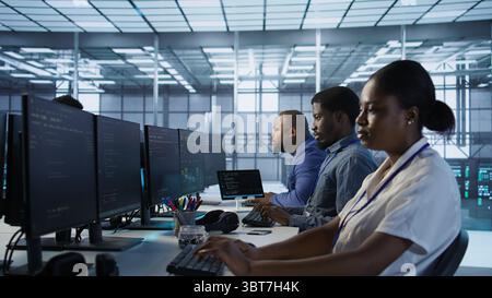 Computer scientists in data center implementing AI predictive maintenance systems. Server farm employees using artificial intelligence to identify hardware failures impacting operations, camera A Stock Photo
