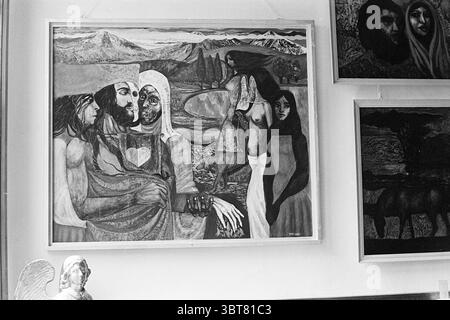Painting on wall, Whizgle News, Dutch Desk, The Netherlands, 1950 - 2000 on 05-1970. These are the elements in the image. The scene features a prominently displayed mural that captures a range of human emotions and expressions. Central to the composition are several figures, each intricately detailed, with their features rendered in a stylized manner. One figure, with a gentle expression, cradles another, creating a sense of intimacy and warmth. The use of monochrome tones lends a timeless quality, highlighting the contrasts between light and shadow. The background showcases a rugged landscape Stock Photo
