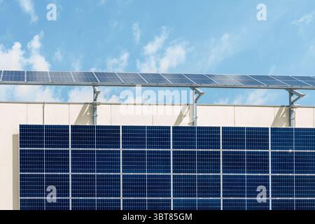 Modern solar panels mounted on the wall of a building under a sunny sky Stock Photo
