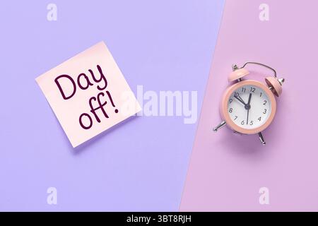 Sticky note with text DAY OFF and alarm clock on color background Stock Photo