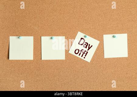 Paper notes with text DAY OFF on cork board Stock Photo