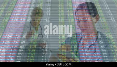 Displaying two doctors donning lab coats and holding stethoscopes in clinic with financial overlay Stock Photo