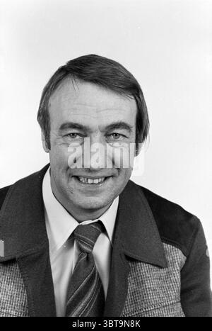 Portrait of Frans Nypels chief of the Haarlems Dagblad city editor, Whizgle News, Dutch Desk, The Netherlands, 1950 - 2000 on 25-08-1980. The image includes these topics. The scene features a man with a friendly, approachable demeanor. He has short hair, with a slight wave, and a well-kept appearance. A broad smile reveals his warm personality, drawing attention to his expressive eyes. He is dressed in a formal collared shirt, topped with a blazer that has a distinct, textured surface, suggesting a sophisticated yet casual style. The color tones of his clothing have an earthiness to them, with Stock Photo