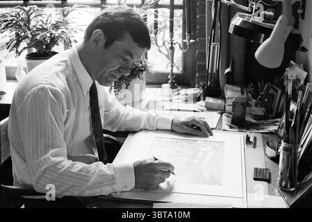 Illustrator Kees de Graaf H'lem Haarlem The Netherlands, Whizgle News, Dutch Desk, The Netherlands, 1950 - 2000 on 11-06-1995. These are the elements in the image. In a cozy, well-lit workspace, a man sits intently at a desk filled with various artistic tools. He is dressed in a collared shirt with fine vertical stripes, exuding a sense of professionalism. A tie adds a touch of formality to his appearance. The man's expression is focused and contemplative as he works on a drawing, carefully positioning his hand over the paper to ensure precision. The desk is a delightful clutter of artistic su Stock Photo