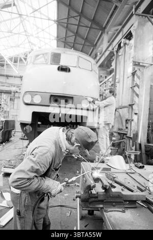 A bustling industrial workshop filled with workers engaged in various ...