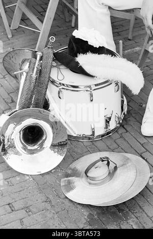 Last day of the Evening Four Days Haarlem - Bato Haarlem Grote Markt The Netherlands, Whizgle News, Dutch Desk, The Netherlands, 1950 - 2000 on 14-06-1980. The image shows these topics. In the scene, a collection of musical instruments rests on a textured surface, likely a wooden floor, exhibiting an arrangement that feels both casual and artistic. A shiny tuba, its polished brass surface reflecting light, rests prominently, showcasing curves and spirals that suggest craftsmanship. Nearby, a white drum with silver hardware stands out against the darker wood, its clean color contrasting with th Stock Photo