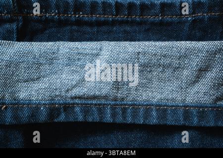 Copy space is created by the folded cuff of blue jeans, where a lighter blue meets the darker denim Stock Photo