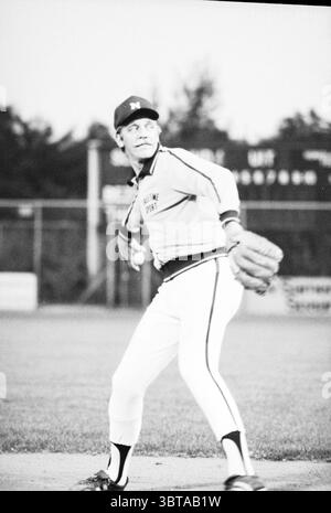 Jan Dik Leurs Nicols Baseball as a pitcher Baseball Haarlem Nicols, Whizgle News, Dutch Desk, The Netherlands, 1950 - 2000 on 01-09-1981. These are the topics in the image. In the scene, a young man stands on a baseball field, poised to pitch. His athletic build is accentuated by a fitted uniform, which features a light-colored top adorned with contrasting stripes. The shirt has a distinctive logo, possibly representing a team or organization. His pants are white, tapering down to his ankles where they meet dark socks, completing the sporty look. The environment around him is typical of a base Stock Photo