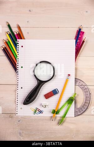 Presenting blank lined notebook in flat design on tabletop with magnifying glass and drawing tools Stock Photo