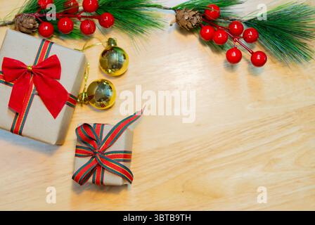 Brown Christmas gift boxes with fir branches and decorations on wooden table. Copy space. Stock Photo