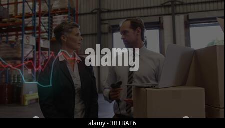 Warehouse staff in business attire scanning stock boxes using scanner and laptop at warehouse Stock Photo