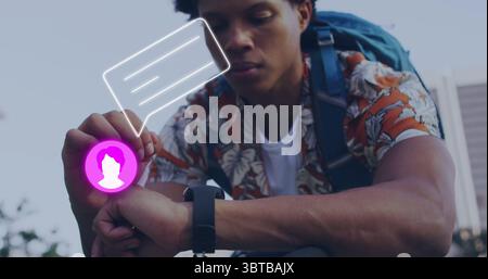 Crouching man wearing floral shirt and blue backpack using smartwatch hologram in city plaza Stock Photo