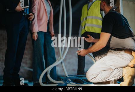 Construction workers and engineers discussing site plans inside a building under renovation Stock Photo