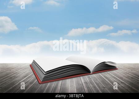 Flat design open red hardcover book is resting on weathered deck under blue sky with clouds Stock Photo