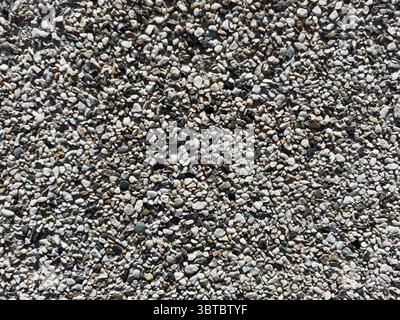 Small stones background, small stones, textured wall. There are some small holes in the wall Stock Photo