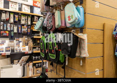 Poznan, Poland - June 30, 2025: Display of various school backpacks and colorful pencil cases hanging on store racks, ready for the exciting academic Stock Photo