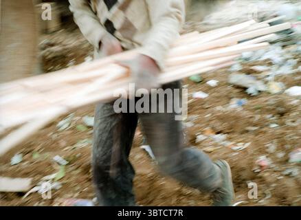 July 20, 2020, Pietermaritzburg, KwaZulu Natal, South Africa: A man carries away wood offcuts, many of these people live in informal shacks near or on the landfill site. This wood could be part of his small home by nightfall. (Credit Image: © John Robinson/ZUMA Wire) Stock Photo
