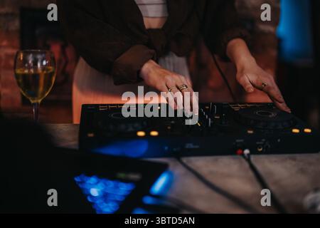 Close-up of hands mixing music on a DJ console at a party Stock Photo