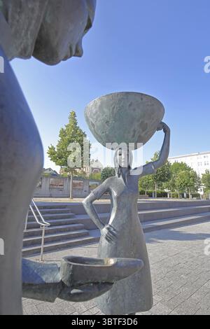 Sculpture Shoe Carrier by Martin Schoeneich 2015, monument to woman during the development of the former shoe industry, shoe production, bronze sculpt Stock Photo