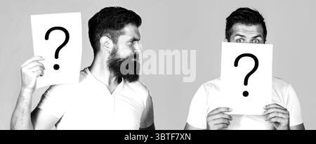 Man with question mark. Anonymous male, peeking behind of interrogation symbol, anonymous, incognita. Paper notes with question marks. Black and white Stock Photo