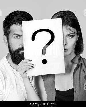 Portrait of couple holding paper question mark. Couple thinking about something. Confused couples with question marks. Conflict between two people Stock Photo