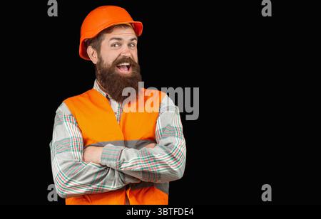 Man with beard wearing safety helmet and reflective jacket smiling, builder. Building, happiness, profession concept. Copy space Stock Photo